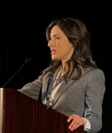 Gina Hinojosa speaking at a podium